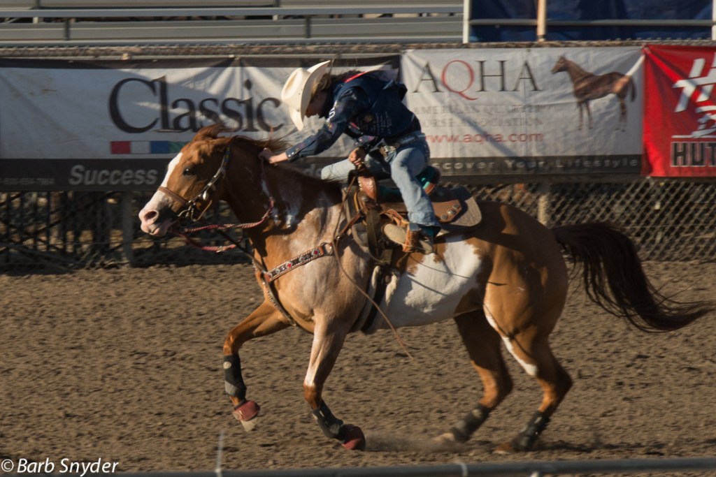 A barrel racer headed home - she's barely in the saddle.